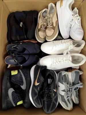 The photo shows a package with footwear in the category SH.