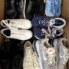 The photo shows a package with footwear in the category SH.