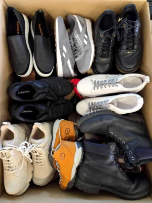 The photo shows a package with footwear in the category SH.