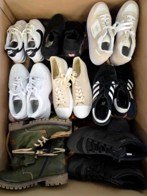 The photo shows a package with footwear in the category SH.