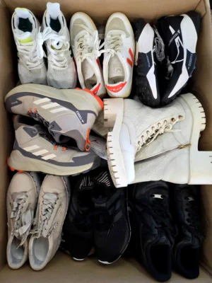 The photo shows a package with footwear in the category SH.