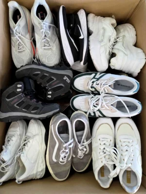 The photo shows a package with footwear in the category SH.