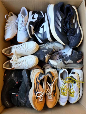 The photo shows a package with footwear in the category SH.