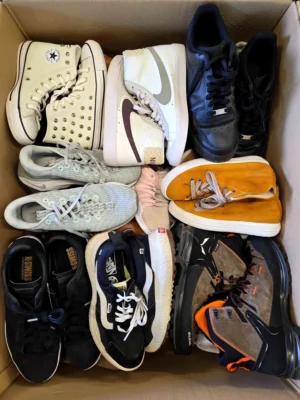 The photo shows a package with footwear in the category SH.