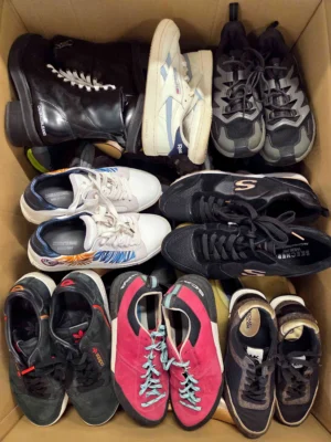 The photo shows a package with footwear in the category SH.