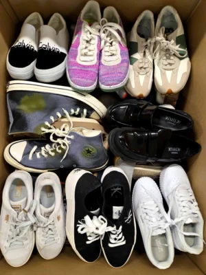 The photo shows a package with footwear in the category SH.