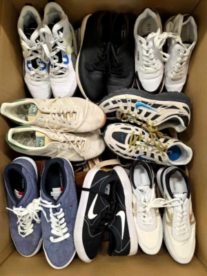 The photo shows a package with footwear in the category SH.