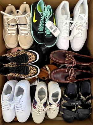 The photo shows a package with footwear in the category SH.