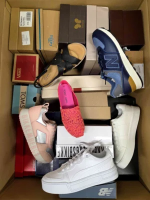 The photo shows a package with footwear in the category AS.