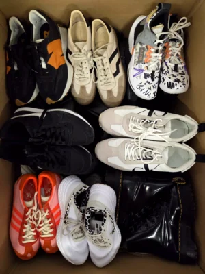 The photo shows a package with footwear in the category SH.