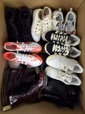 The photo shows a package with footwear in the category SH.