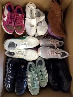 The photo shows a package with footwear in the category SH.