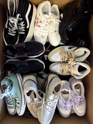 The photo shows a package with footwear in the category SH.