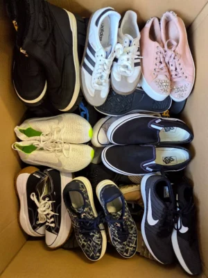 The photo shows a package with footwear in the category SH.