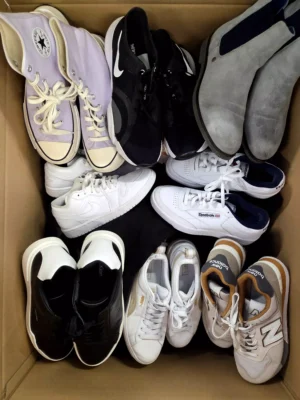 The photo shows a package with footwear in the category SH.