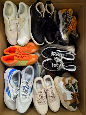 The photo shows a package with footwear in the category SH.