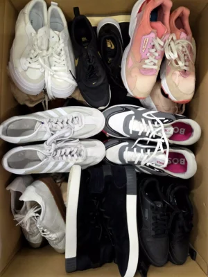 The photo shows a package with footwear in the category SH.