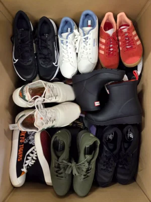The photo shows a package with footwear in the category SH.