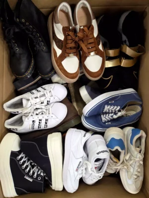 The photo shows a package with footwear in the category SH.
