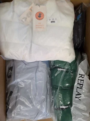 The photo shows a package with clothing in the category AJW.