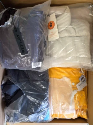 The photo shows a package with clothing in the category AJW.